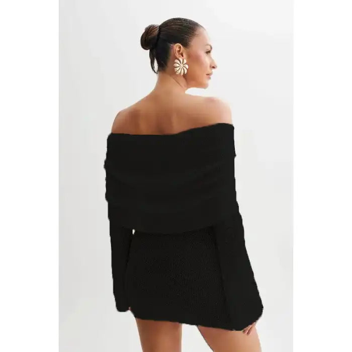 Knitted black dress back view showing off-shoulder fit and textured sleeve details.