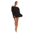 Knitted mini dress in black with long sleeves, off-shoulder neckline, and white heels.