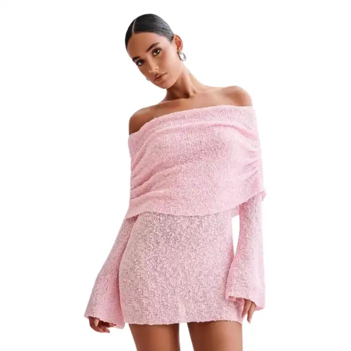 Knitted dress in pink featuring off-shoulder style and flared sleeves on model.