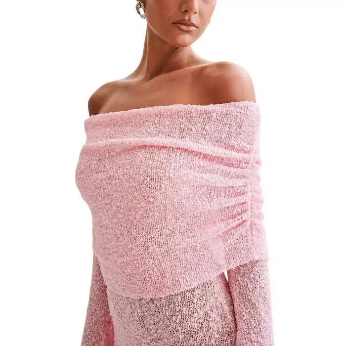Knitted pink dress close-up highlighting textured fabric and off-shoulder neckline detail.