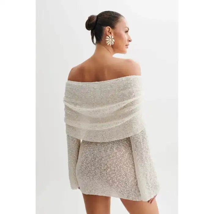 Knitted dress in white shown from back with ruched off-shoulder detail and soft drape fit.