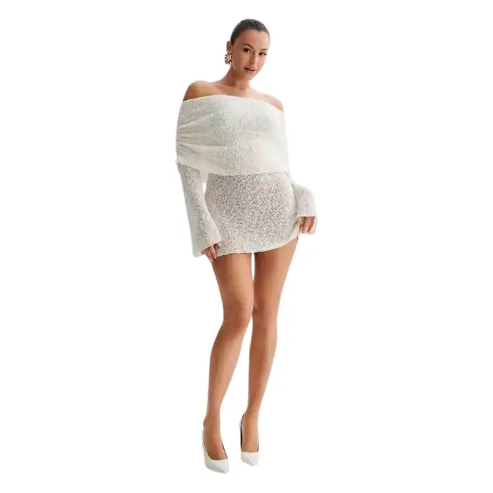 Knitted dress in white styled with long sleeves and elegant off-shoulder cut in front pose.