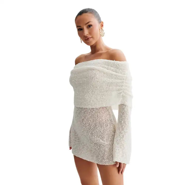 Knitted white dress close-up showing off-shoulder neckline and sparkly textured yarn detail.
