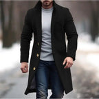 Lapel trench coat in black with gold buttons styled for winter streetwear on a snowy outdoor path.