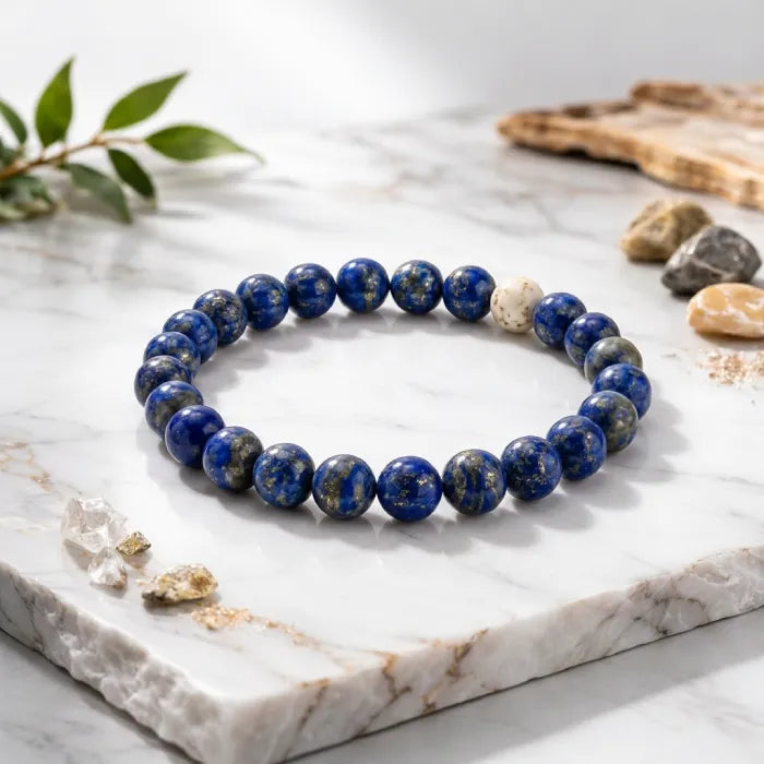 Lapis lazuli bracelet on white marble with crystals, premium gemstone bead jewelry for luxury display appeal.