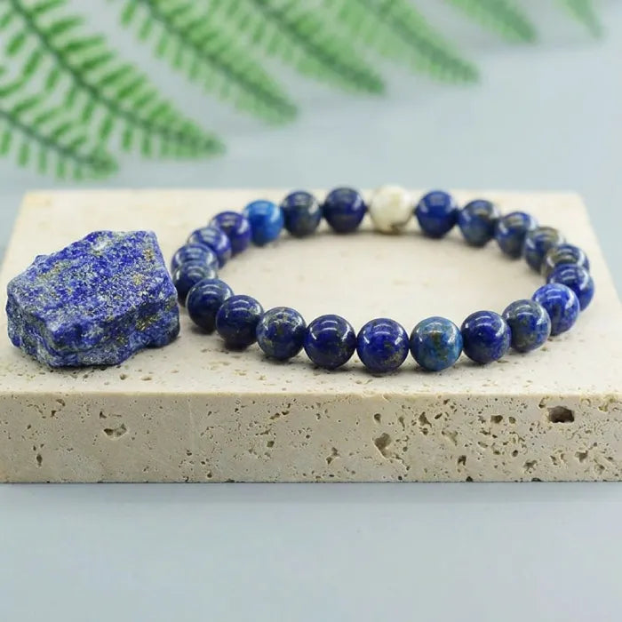 Lapis lazuli bracelet on natural stone slab with raw crystal, polished gemstone bead jewelry for elegant earthy style