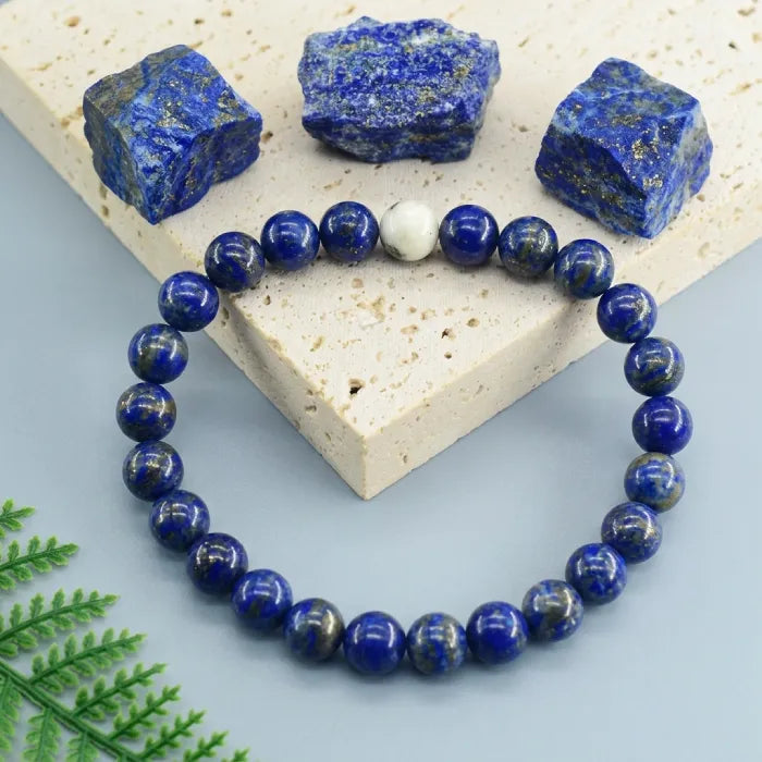 Lapis lazuli bracelet with raw blue gemstones on stone slab, polished crystal bead jewelry for natural luxury appeal