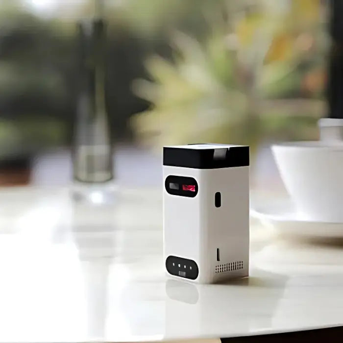 Laser keyboard device shown on table with compact white body and black top.