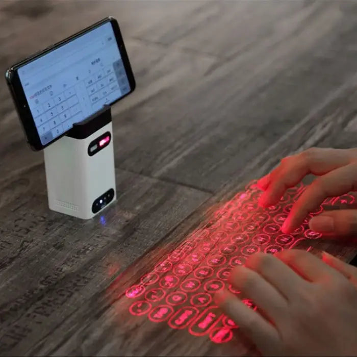 Laser keyboard for smartphone projecting red keyboard on table with hand typing.