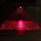 Red laser keyboard projected onto a dark surface with a remote control.