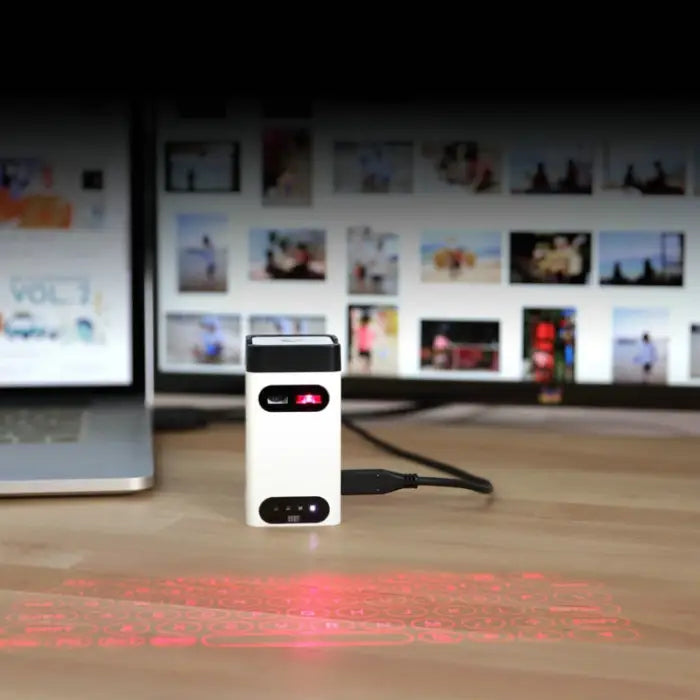 Laser projection keyboard plugged into laptop USB projecting virtual keyboard on wooden desk.