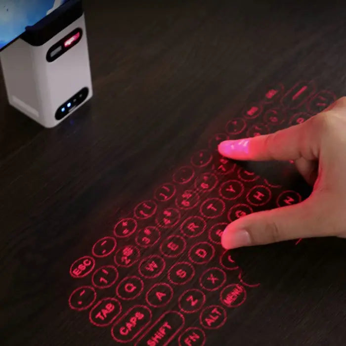 Laser projection keyboard projecting virtual red keyboard onto wooden surface with hand typing.