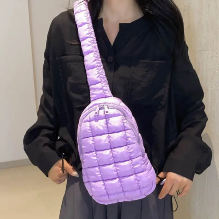 Lavender puffer sling bag worn with black shirt and gray skirt, demonstrating urban street style