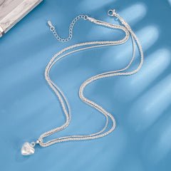 layered silver heart necklace laid flat showing full chain length brushed heart pendant and adjustable clasp