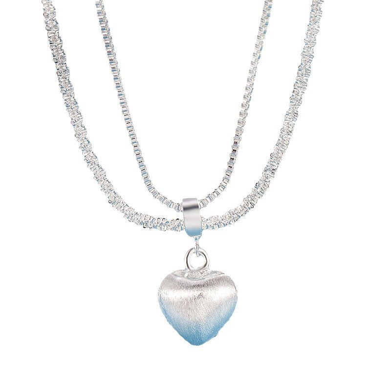 layered silver heart necklace with brushed pendant displayed on white background highlighting dual chain design