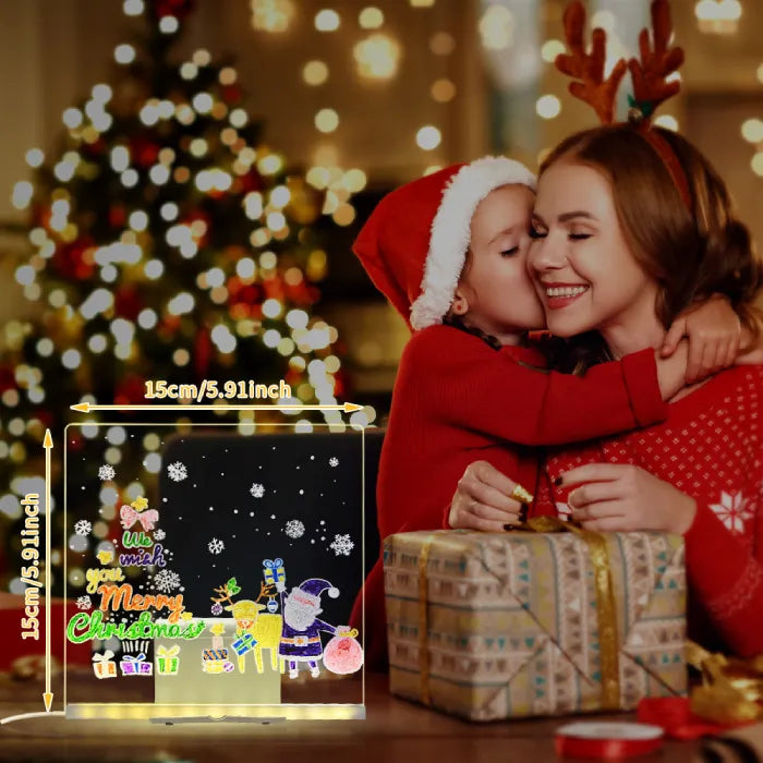 LED acrylic drawing board glowing with Merry Christmas artwork beside a mother and child, creating a festive light-up holiday gift moment.