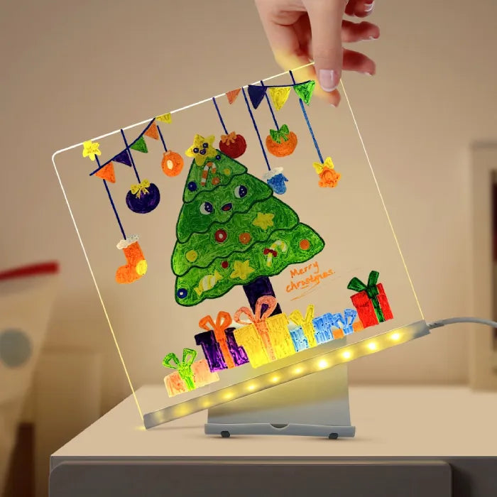 LED acrylic drawing board with colorful Christmas tree and gifts illustration glowing brightly, adding festive cheer to seasonal creative decor.