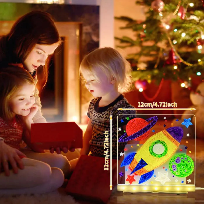 LED acrylic drawing board displaying glowing rocket artwork as children open presents, creating a bright festive space-themed light scene.