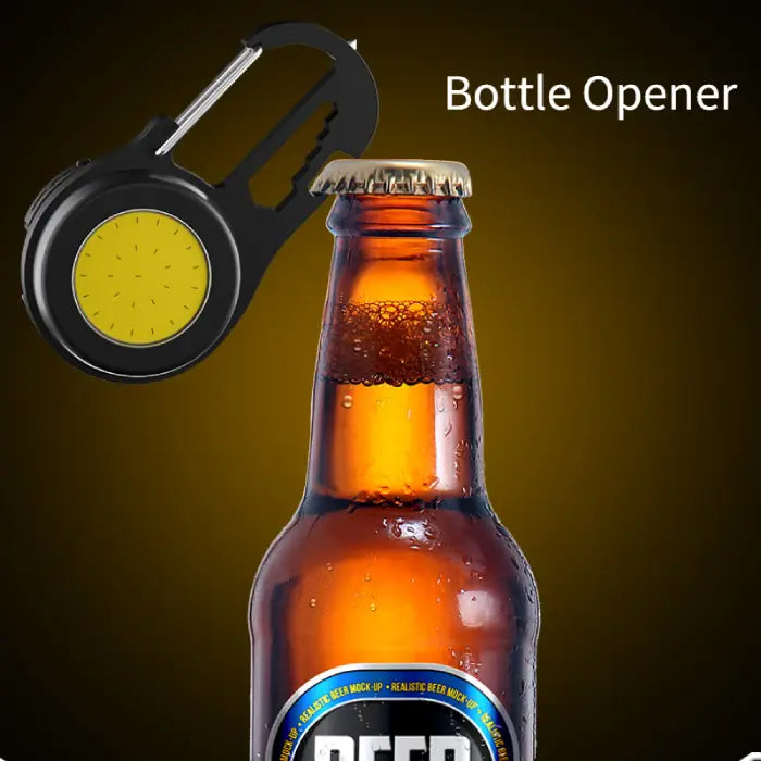 Black LED carabiner light being used as bottle opener with amber beer bottle