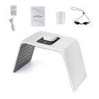 LED light therapy device kit including machine, adapter, manual, cup, and protective goggles.