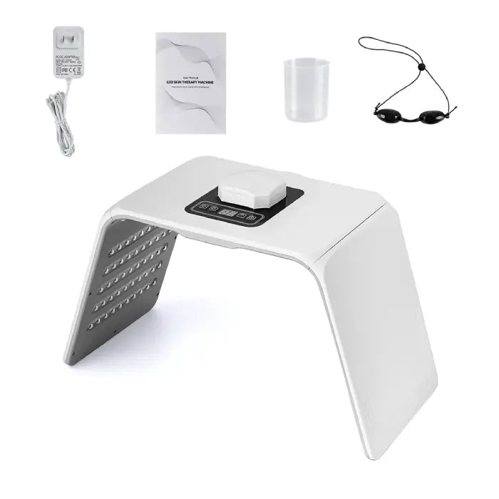 LED light therapy device kit including machine, adapter, manual, cup, and protective goggles.