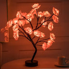 LED tree lamp in dark setting with glowing red rose bouquet on a black stand for home ambiance lighting.