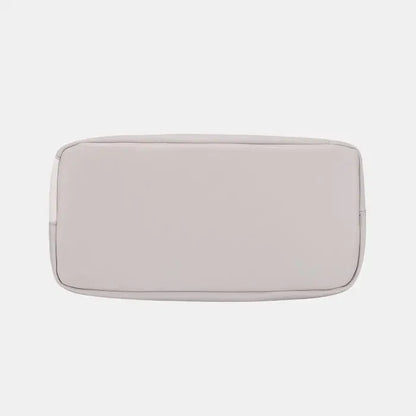 Bottom view of light gray handbag, displaying structured rectangular shape and clean lines