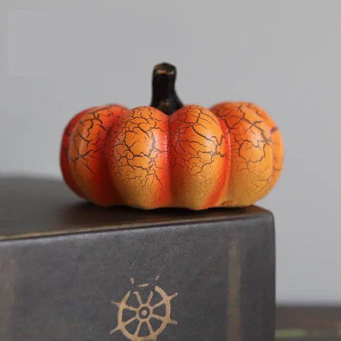 Light up pumpkin decorations in mini size with orange crackled surface and black stem on display
