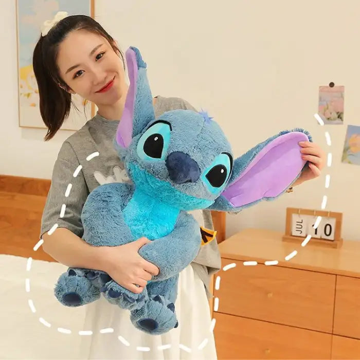 lilo and stitch large plush toy held by smiling woman indoors with hand-drawn accents