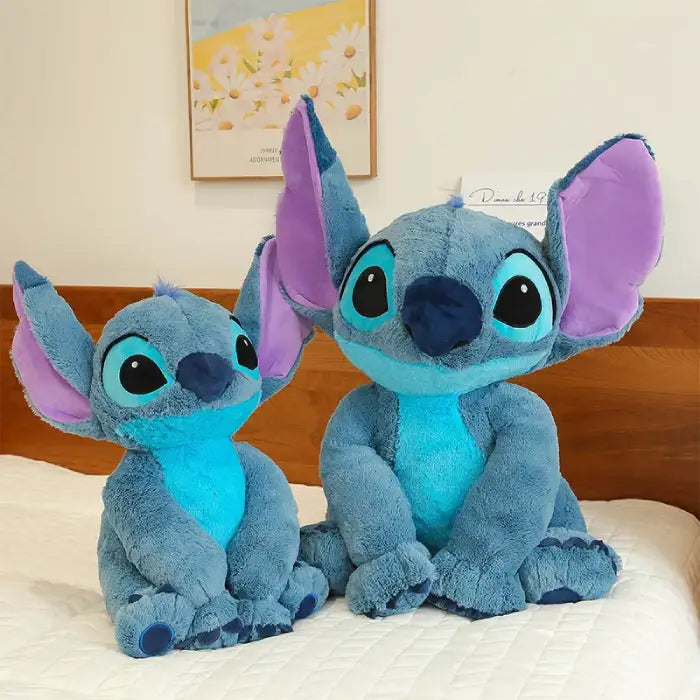 lilo and Stitch medium-sized plush toys sitting on bed side by side
