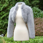 long sleeve faux fur bolero jacket in grey displayed on mannequin, offering a chic cropped design ideal for winter evening fashion