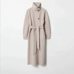 Long tweed coat women in beige shown with a high-neck tailored silhouette and belt detail, highlighting premium wool winter craftsmanship