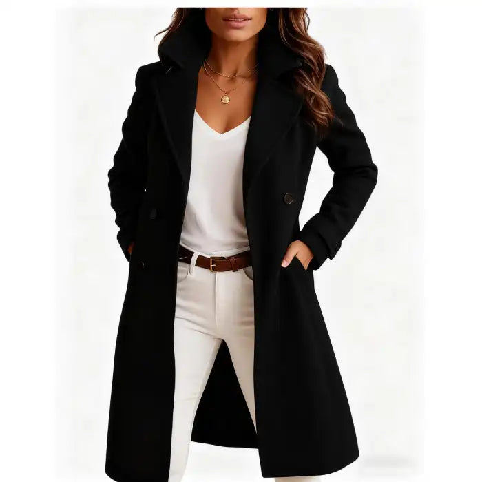 Long wool coat in black with double-breasted design and wide lapels styled over white outfit.