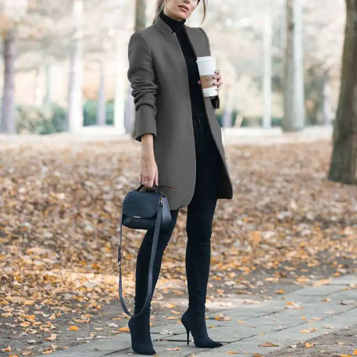 longline coat women in gray paired with black turtleneck and boots outdoors
