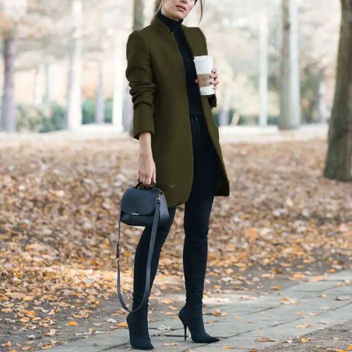 longline coat women in olive green walking outside with handbag and coffee cup