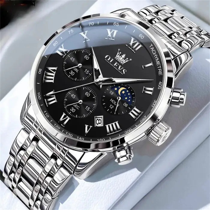Luminous stainless steel watch with black dial, Roman numerals, chronograph subdials, moon phase indicator and polished link bracelet