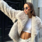 Luxury faux fur coat in beige worn by model with white crop top, highlighting soft plush fibers and trendy casual winter street styling