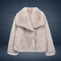 Luxury faux fur coat in beige shown on dark backdrop with wide collar and plush fibers, highlighting premium warm winter outerwear style