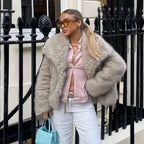 Luxury faux fur coat in beige worn with pink top and white pants, showcasing plush texture and chic street-style winter fashion look