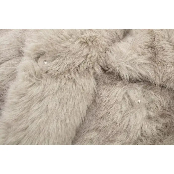 Luxury faux fur coat close-up showing plush beige fibers and hidden fastener, highlighting premium soft texture for elegant outerwear appeal