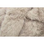 Luxury faux fur coat close-up showing plush beige fibers and hidden fastener, highlighting premium soft texture for elegant outerwear appeal