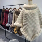 Luxury Fur-Trimmed Knit Poncho collection hanging neatly on rack, showcasing assorted winter colors and soft fur-trimmed knit design