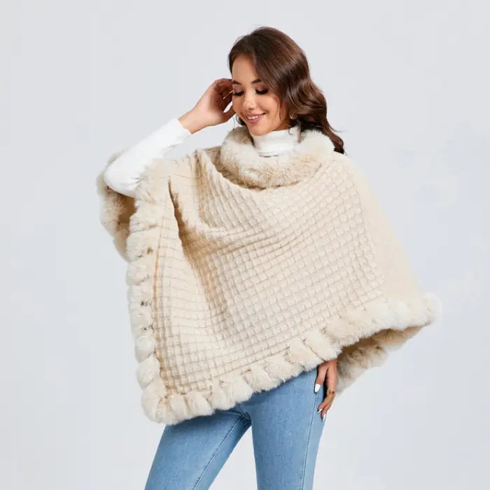 Luxury Fur-Trimmed Knit Poncho in soft cream shown at an angle, emphasizing plush trim and warm knit texture for winter fashion shoppers