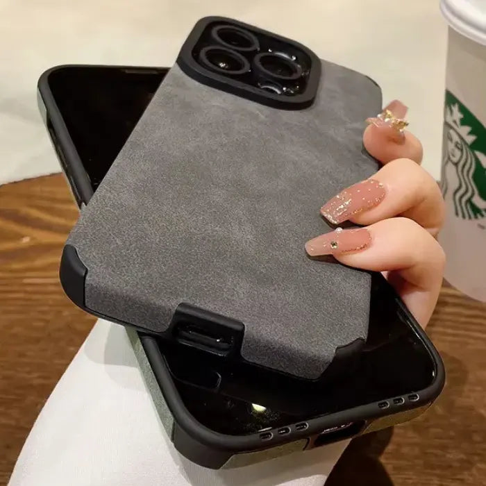 Luxury suede phone cover in grey placed over another phone, highlighting its premium suede case texture and strong dual-layer protection.