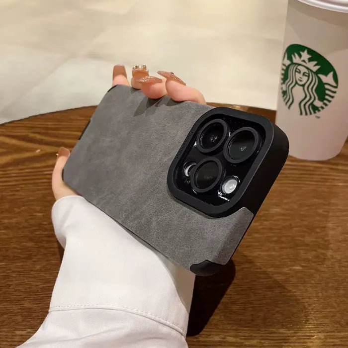 Luxury suede phone cover in grey held in hand, showing a premium textured suede case design with protective minimalist styling.