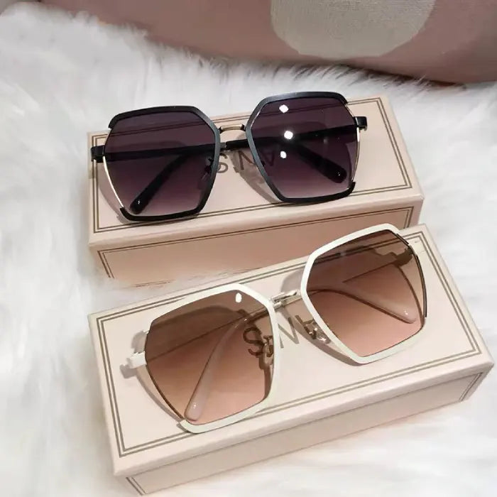 Luxury designer oversized square sunglasses in black and white frames with gradient lenses displayed on branded boxes