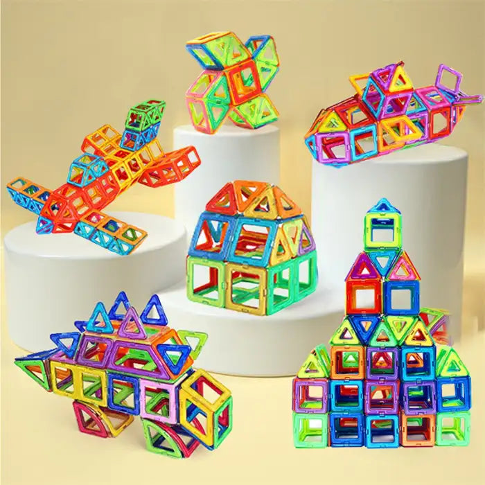 Magnetic building blocks forming 3D models of planes, houses, towers, and geometric shapes on display.