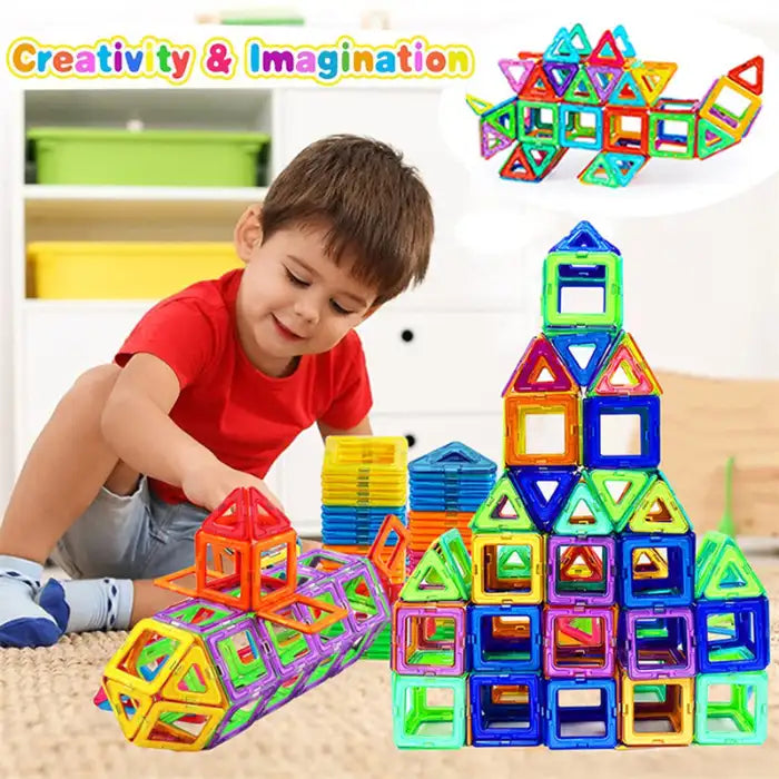 Boy in red shirt playing with magnetic building blocks, building colorful rocket and pyramid shapes.