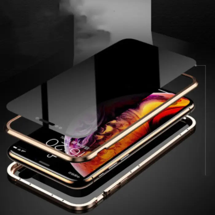 Gold-framed magnetic iPhone case with a reflective mirror design placed on a desk with pens.