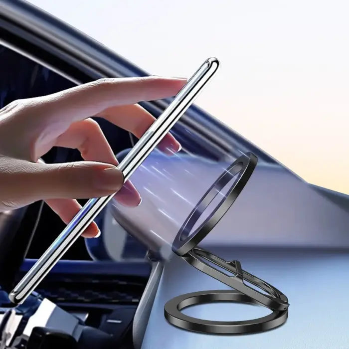 Magnetic phone holder mounted in car with hand placing phone near magnetic ring for attachment.